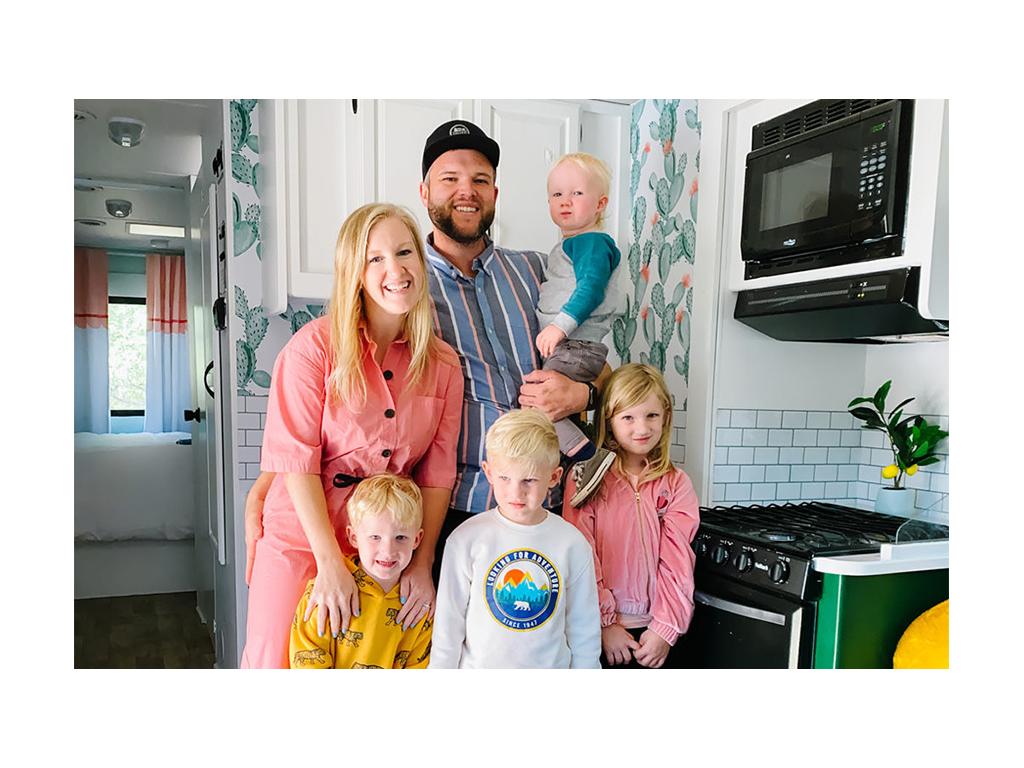 Wages family smiling for a photo inside their newly renovated Minnie Winnie