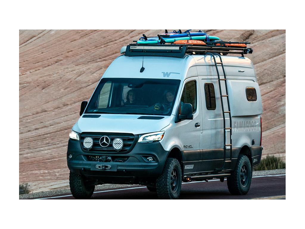Kathy driving Revel with Abby in passenger seat. Dual roof rack is on top of Revel