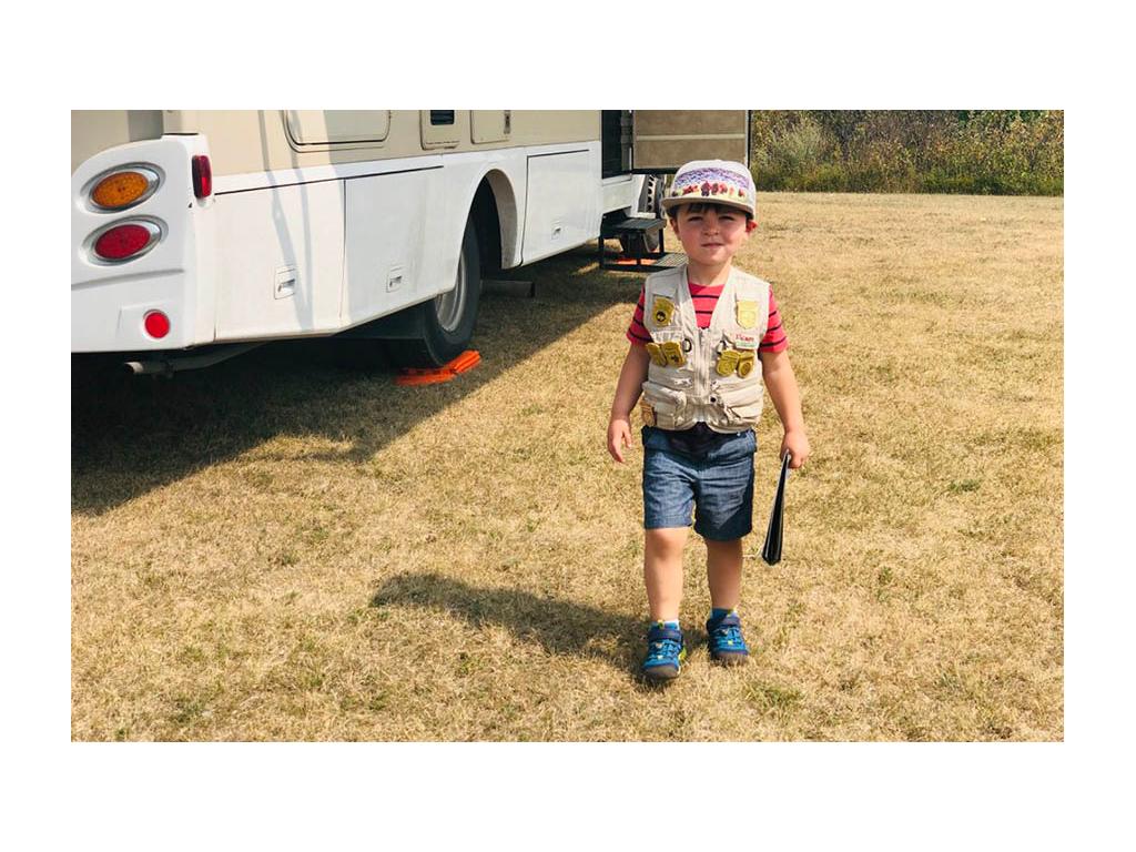 Caspian wearing ranger vest standing next to Winnebago View
