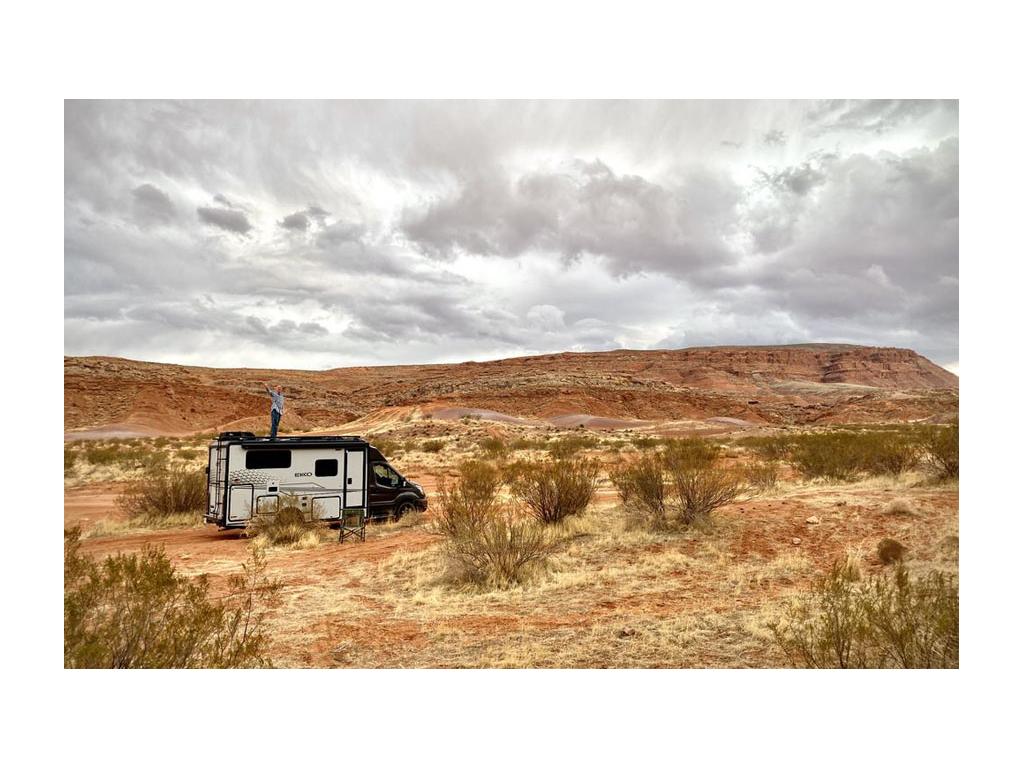 James standing on top of EKKO parked in desert