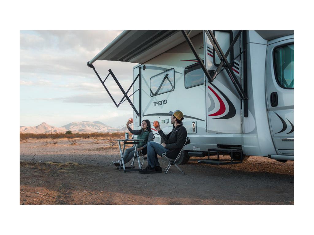 Nadia and Jon sitting outside of Trend at table drinking wine under awning