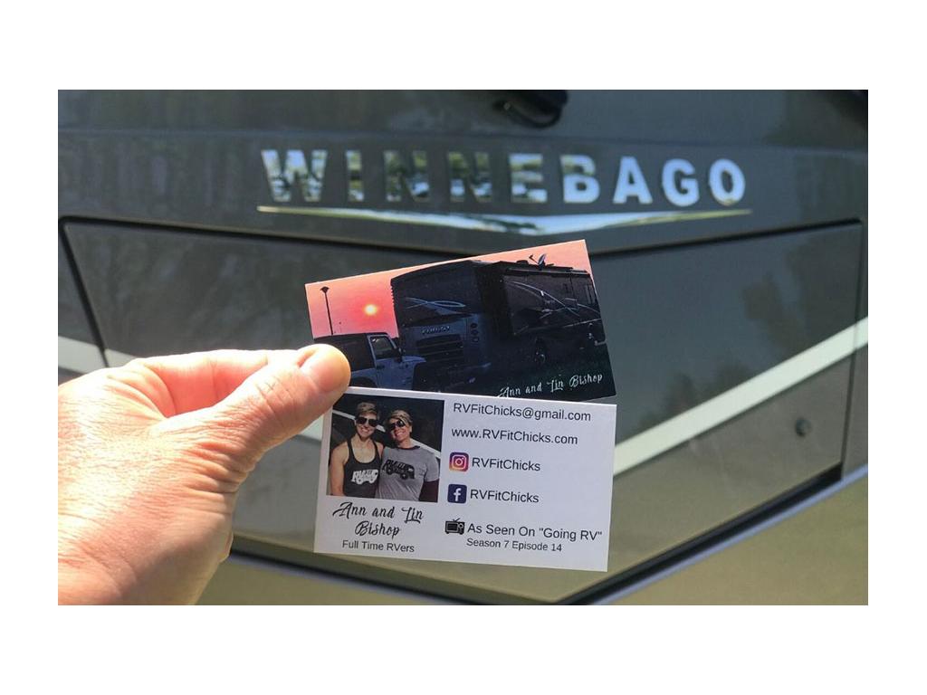 Card with contact information held up in front of Winnebago Forza