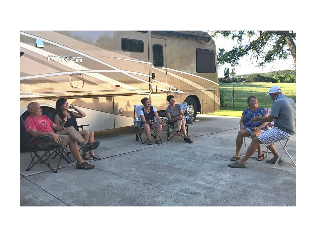 Ann & Lin sitting in front of Forza with friends at a distance
