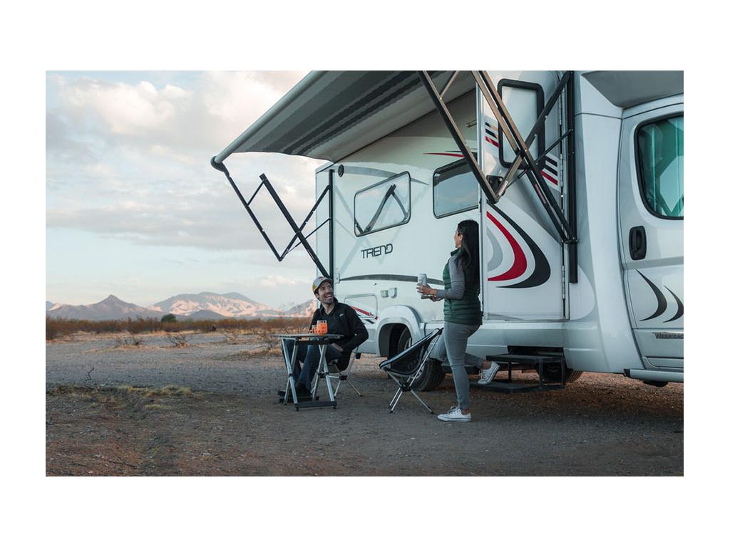 Nadia standing on step of Trend with door open looking at Jon sitting at table outside of Trend.