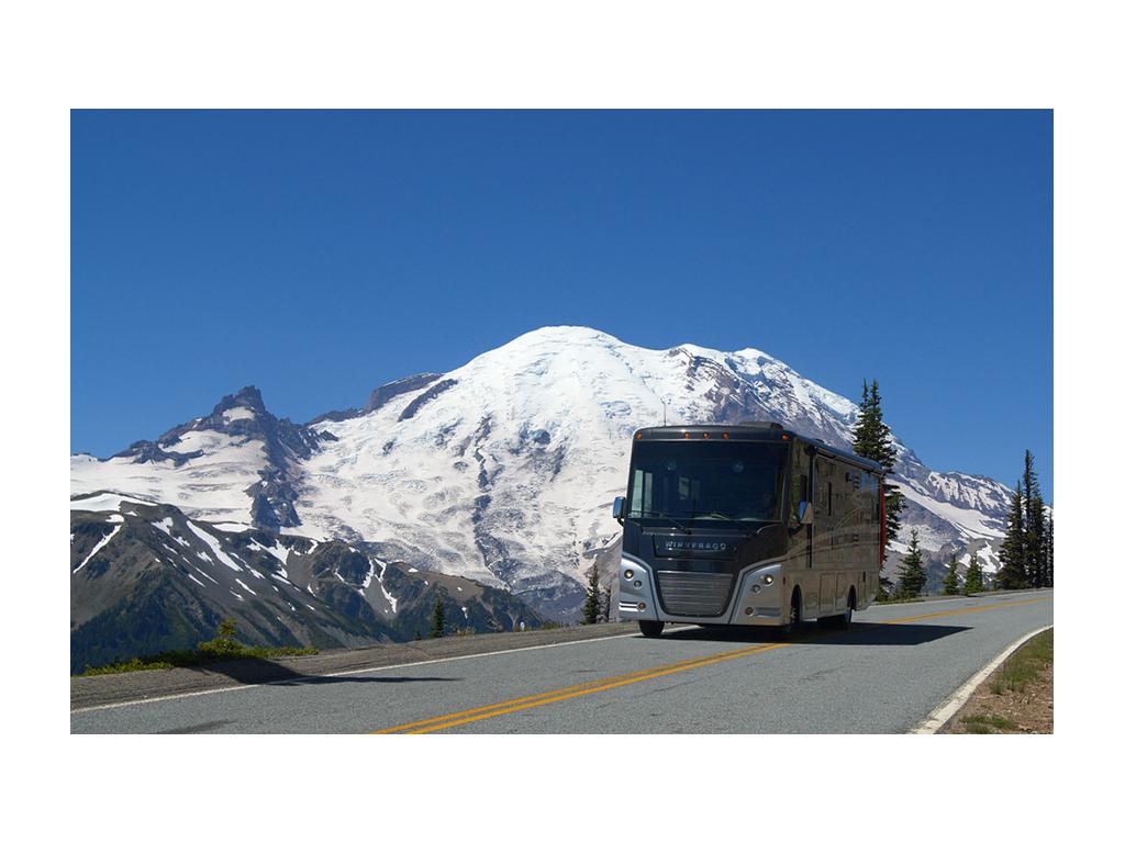 Adventurer driving through snow capped mountains