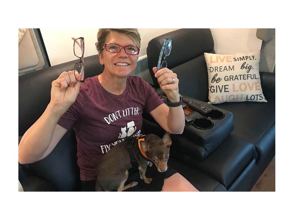 Lin holding up two pairs of glasses while Wally sits on her lap