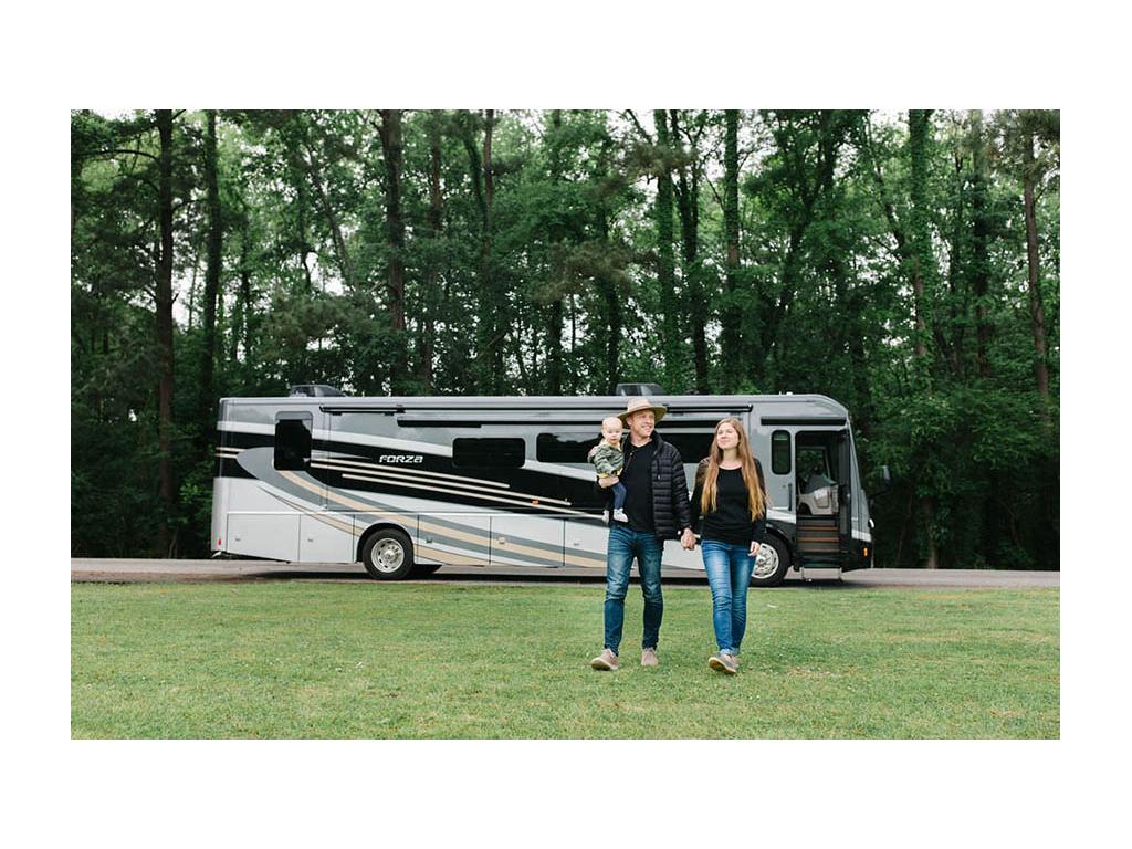 Heath, Alyssa and Ellie walking in grass with Forza parked in the background