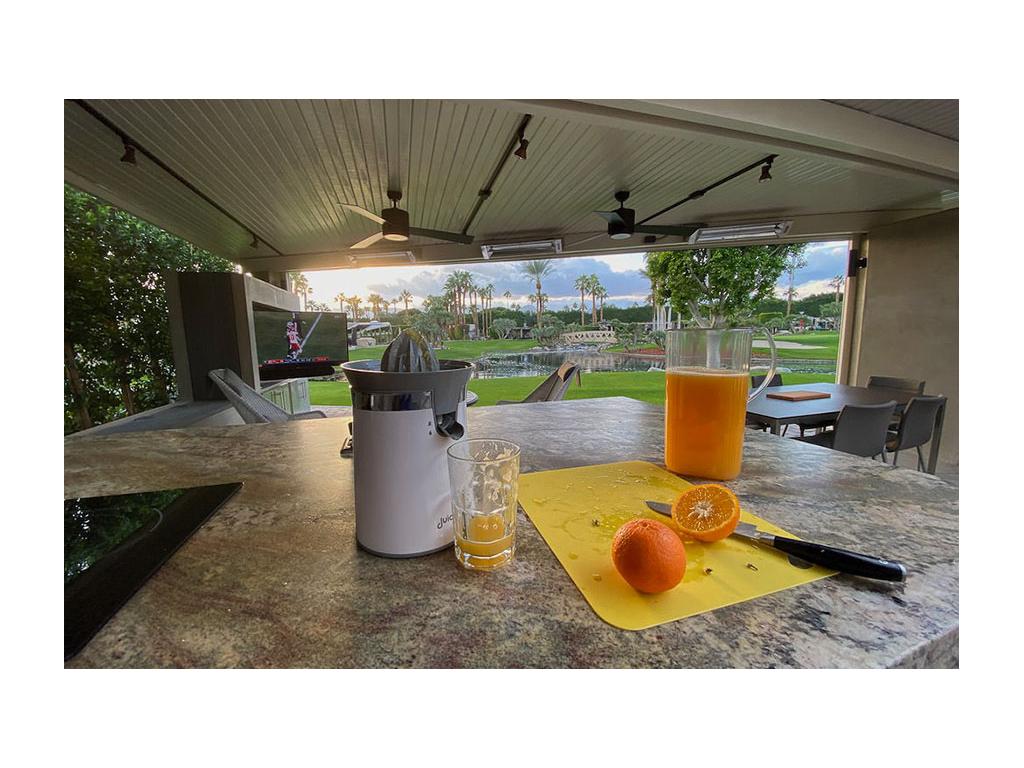 Freshly squeezed orange juice and oranges on the counter
