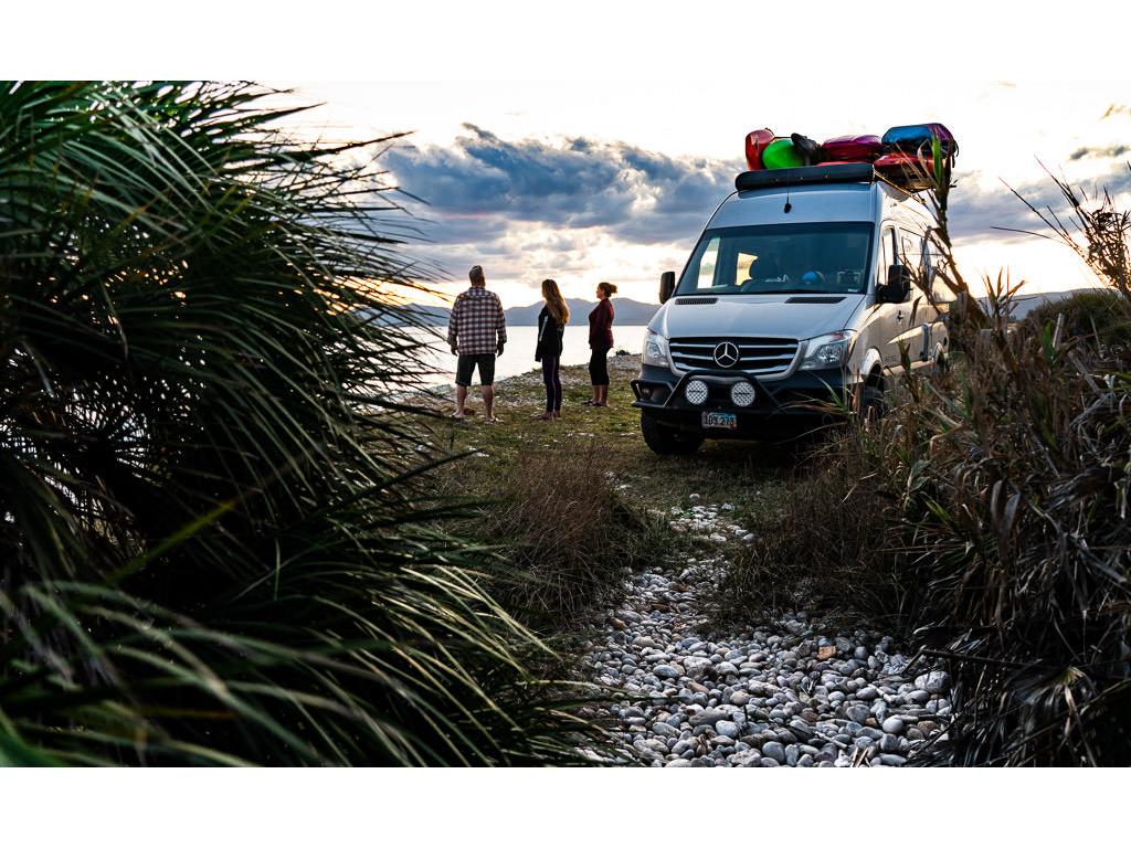 Winnebago Revel parked with Holcombe family overlooking beautiful body of water