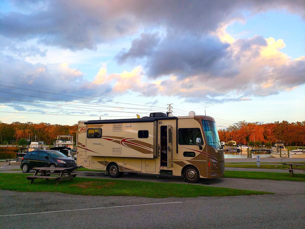 Winnebago Vista parked at KOA site with trees surrounding