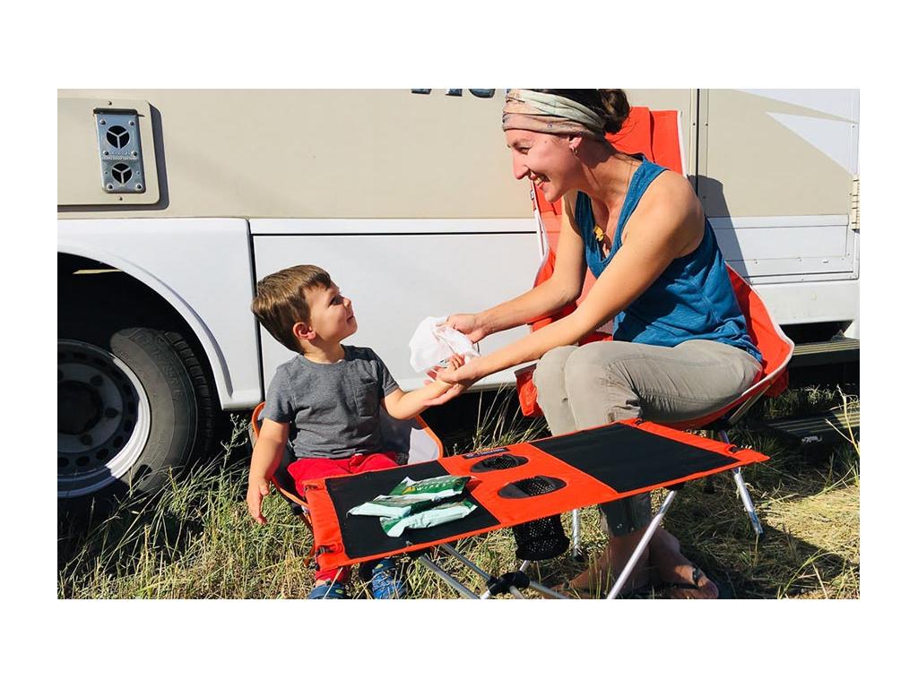 Brittany cleaning off Caspian's hands while sitting at a table in front of View