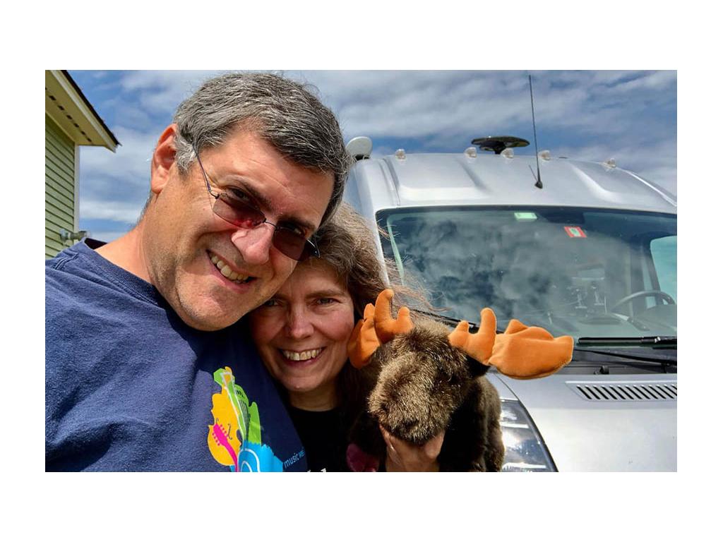 Daniel and Faith smiling holding stuffed Moose toy in front of Travato