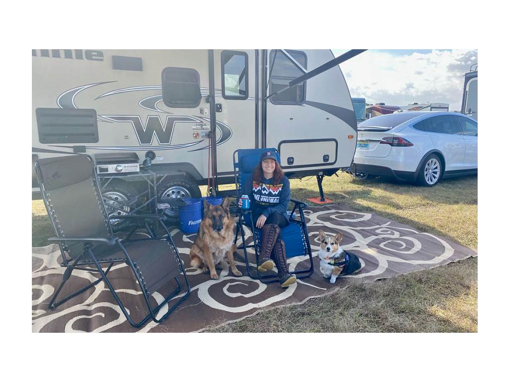 Becca sitting next to two dogs outside of Micro Minnie