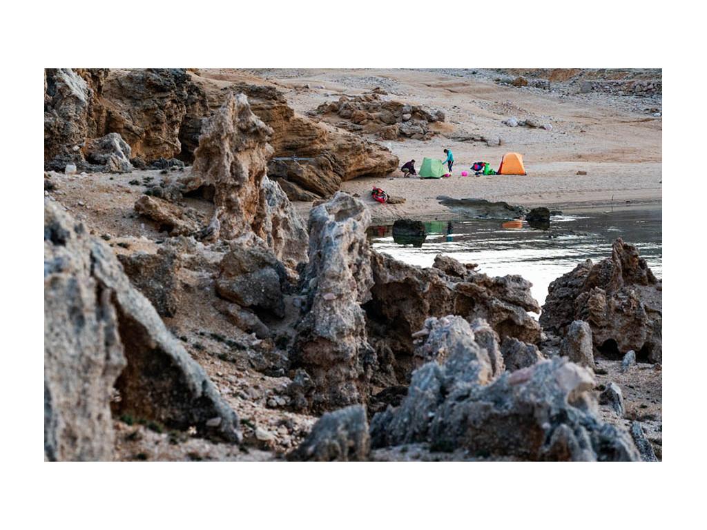 Abby and Kathy setting up tents at campsite near water