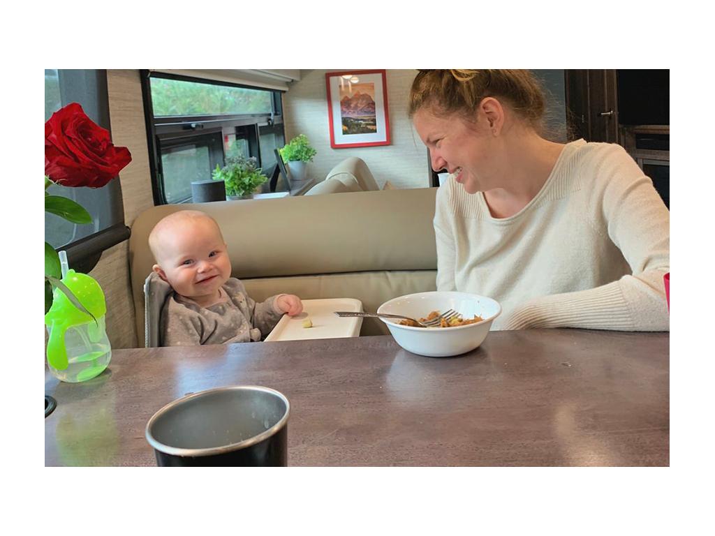 Alyssa and Ellie smiling while eating at dinette