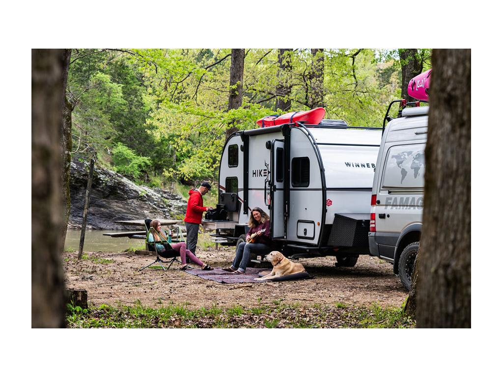 Holcombe family sitting outside of their Winnebago Hike with their dog Tucker