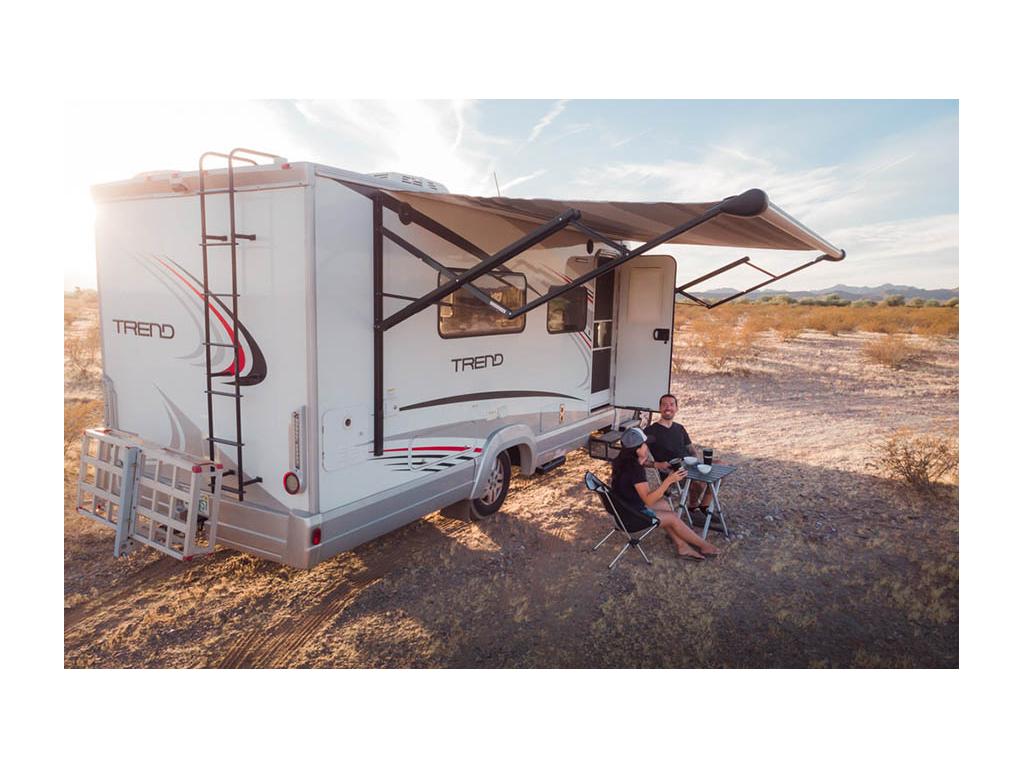 Nadia and Jon sitting outside of Trend next to small table drinking coffee