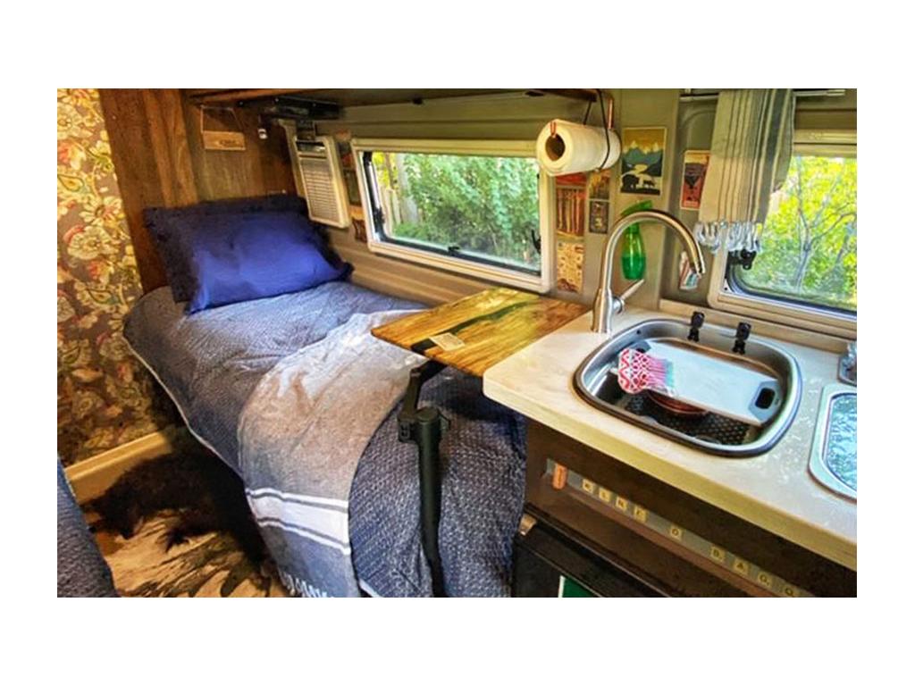 Wooden desk in Travato over driver side bed