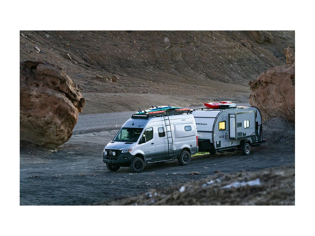 Winnebago Revel pulling Winnebago HIKE with surf boards and kayaks on top