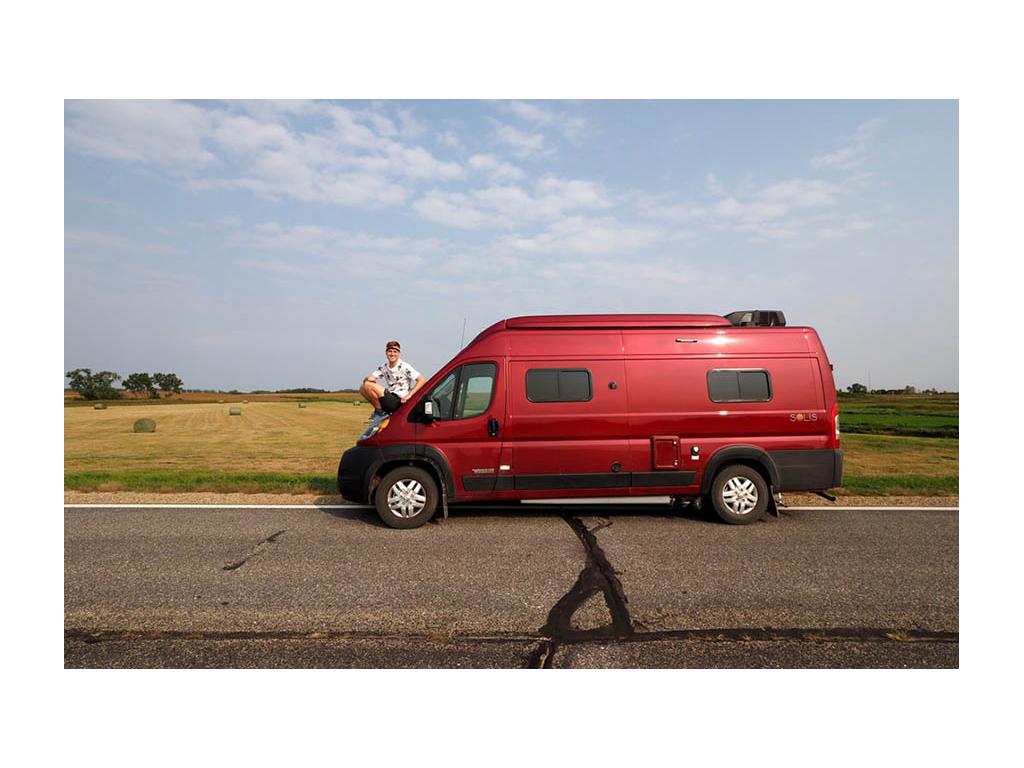 Mikah sitting on hood of Solis smiling