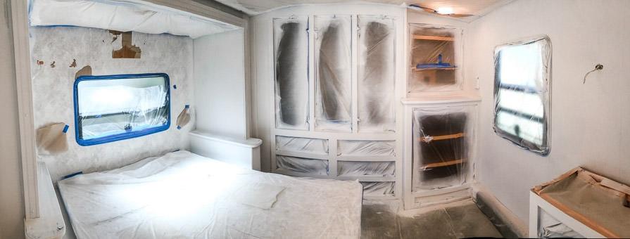 Bedroom mid-renovation with plastic and blue tape protecting from paint