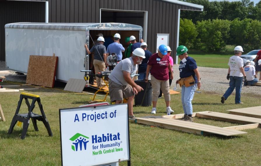 RV Care-A-Vanners laying out shed in grass