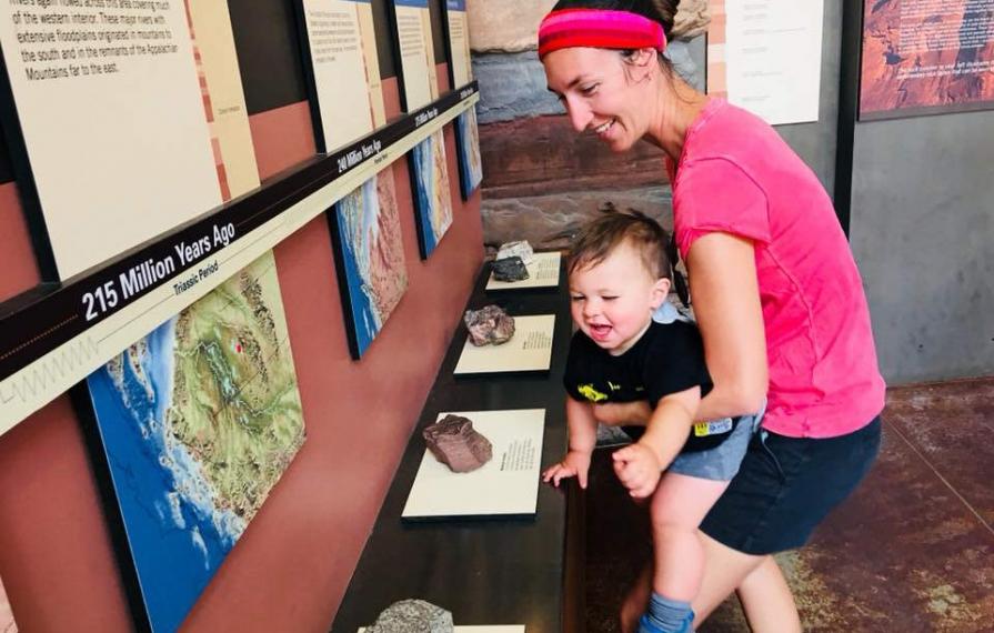 Brittany holding Caspian up to touch rocks