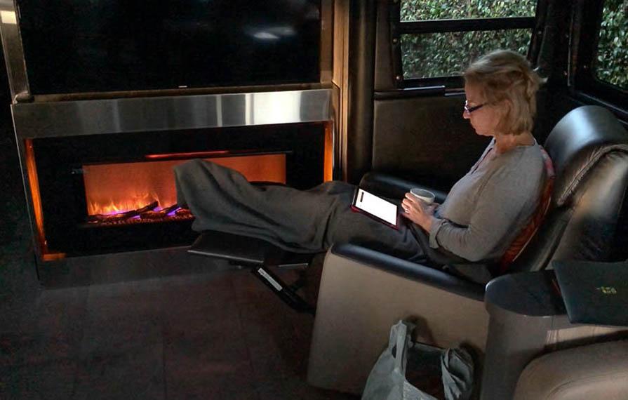 Terry sitting in front of Horizon fireplace drinking coffee