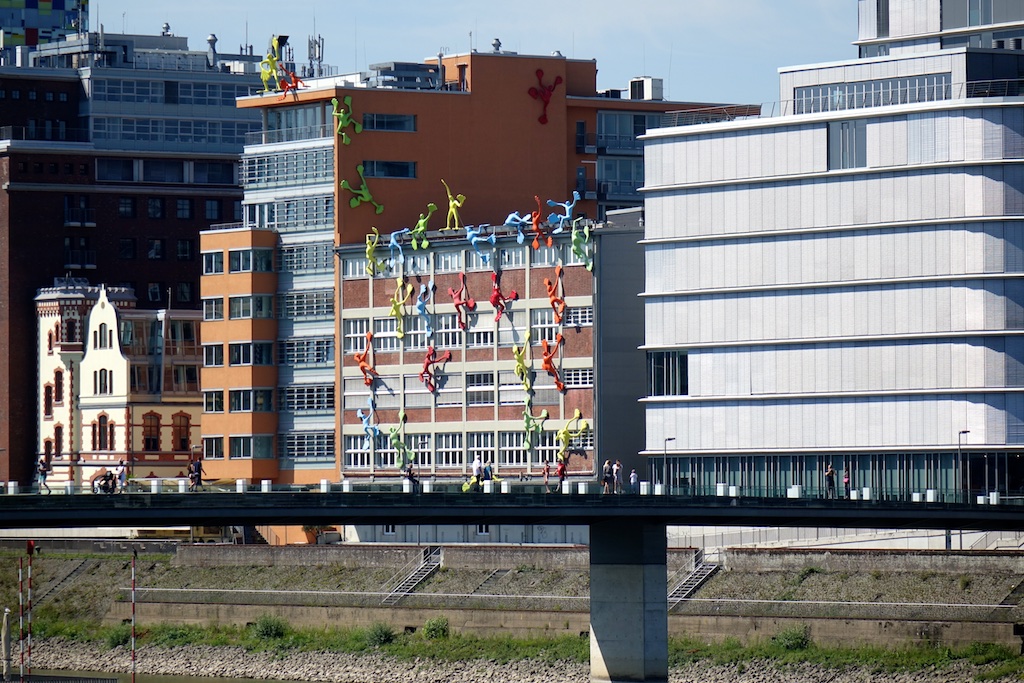 Dusseldorf building with sculpted figures that appear to be climbing the side of the building.