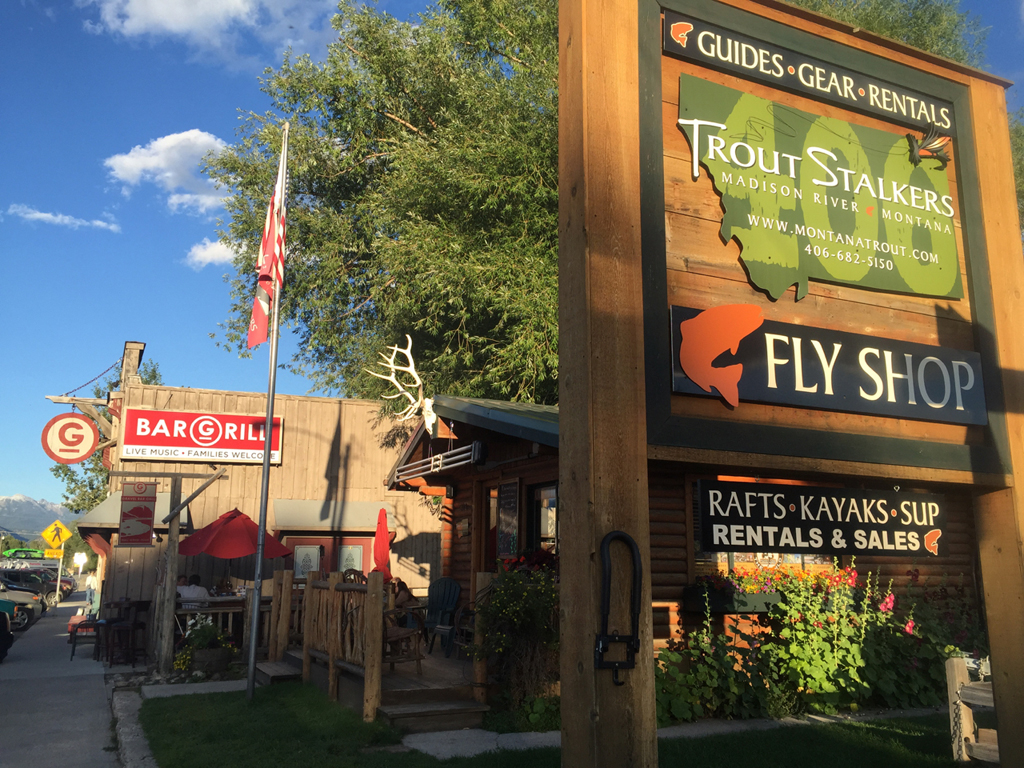 Trout Stalkers sign and Bar and Grill sign in front of pictures. 
