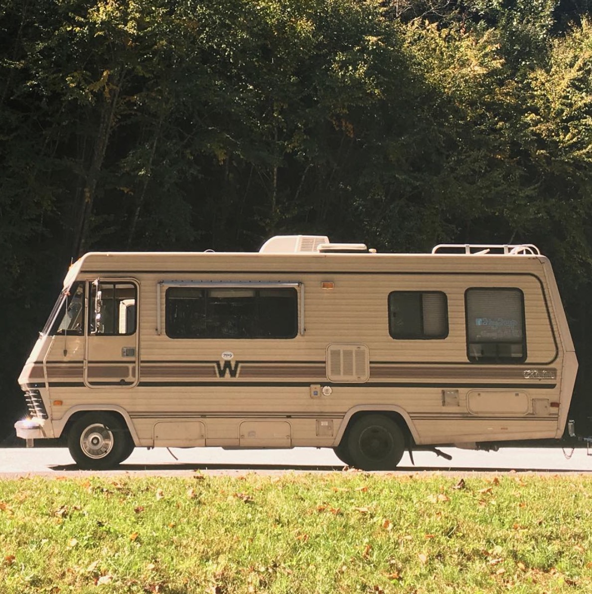 Old Winnebago motorhome parked alongside the road.