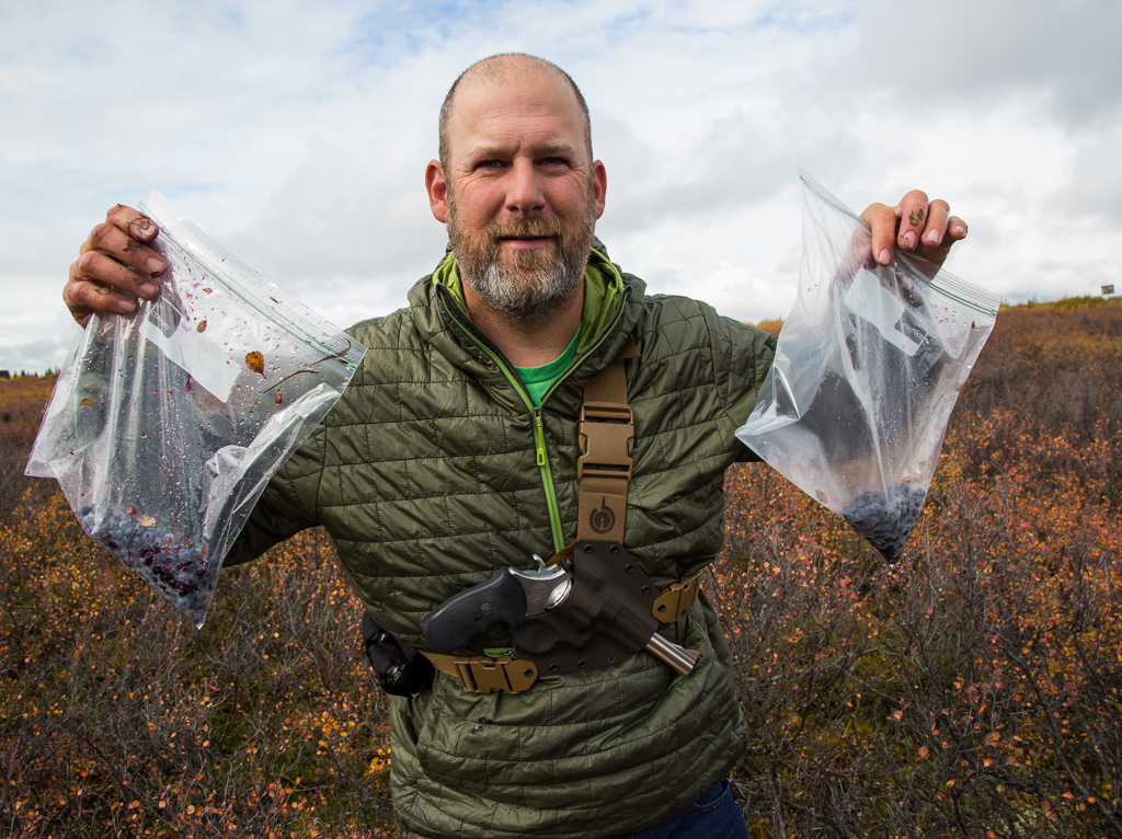 Peter holding two bags with blueberries.