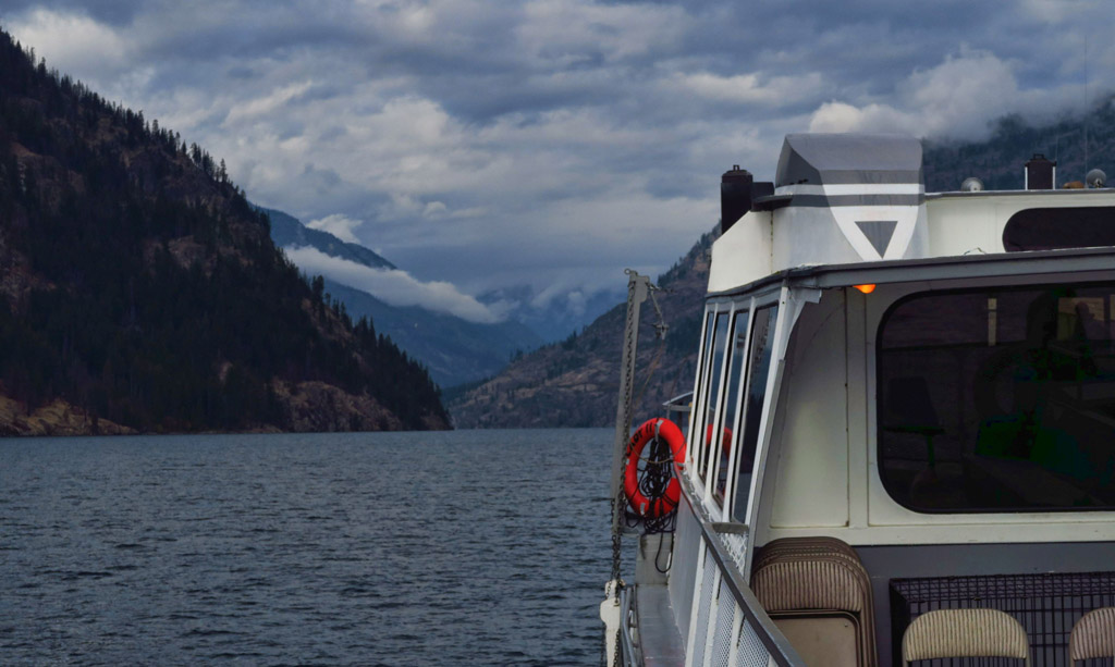 Ferry on the water with mountains ahead.