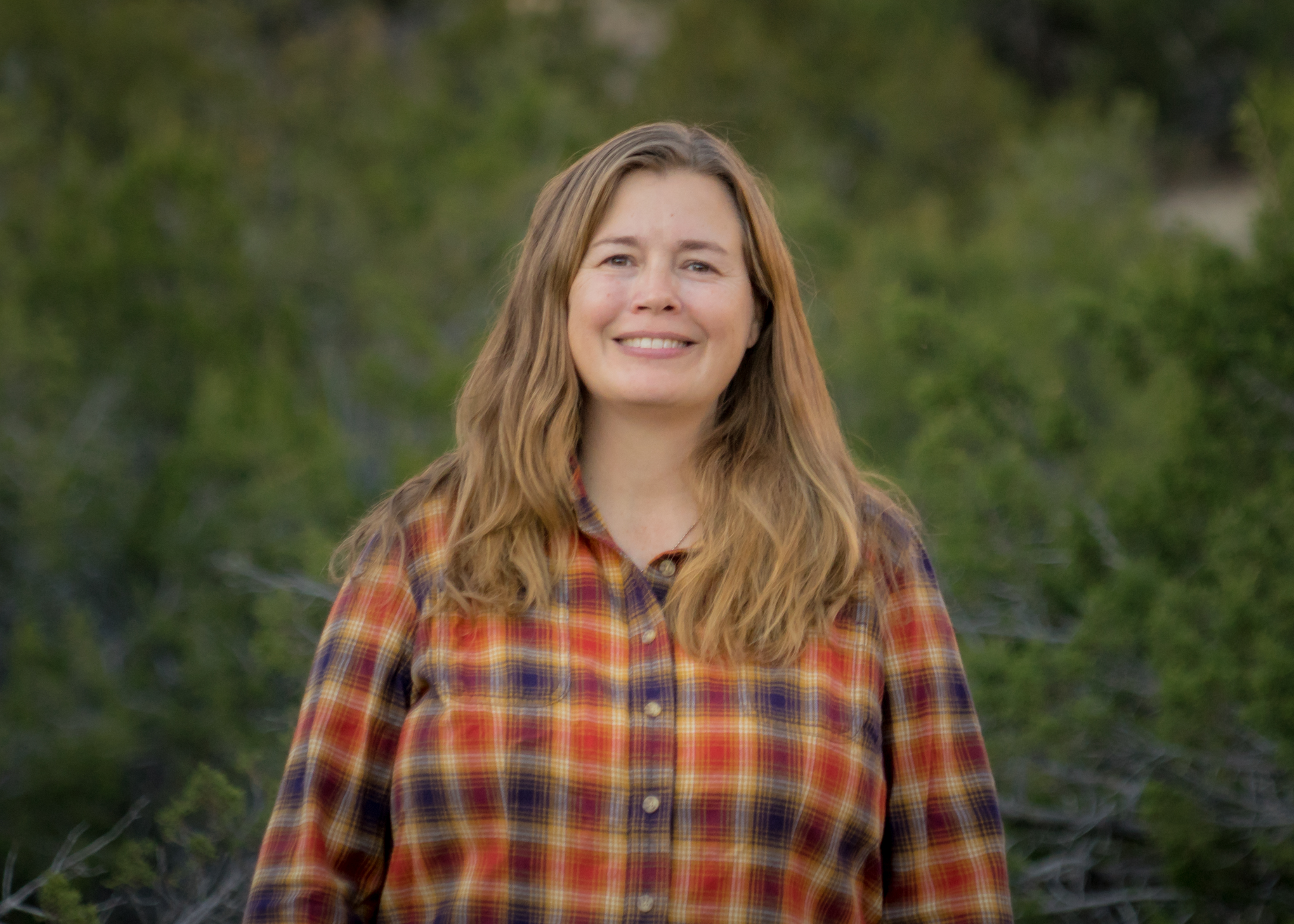 Headshot of Kate Mullen with trees as backdrop.