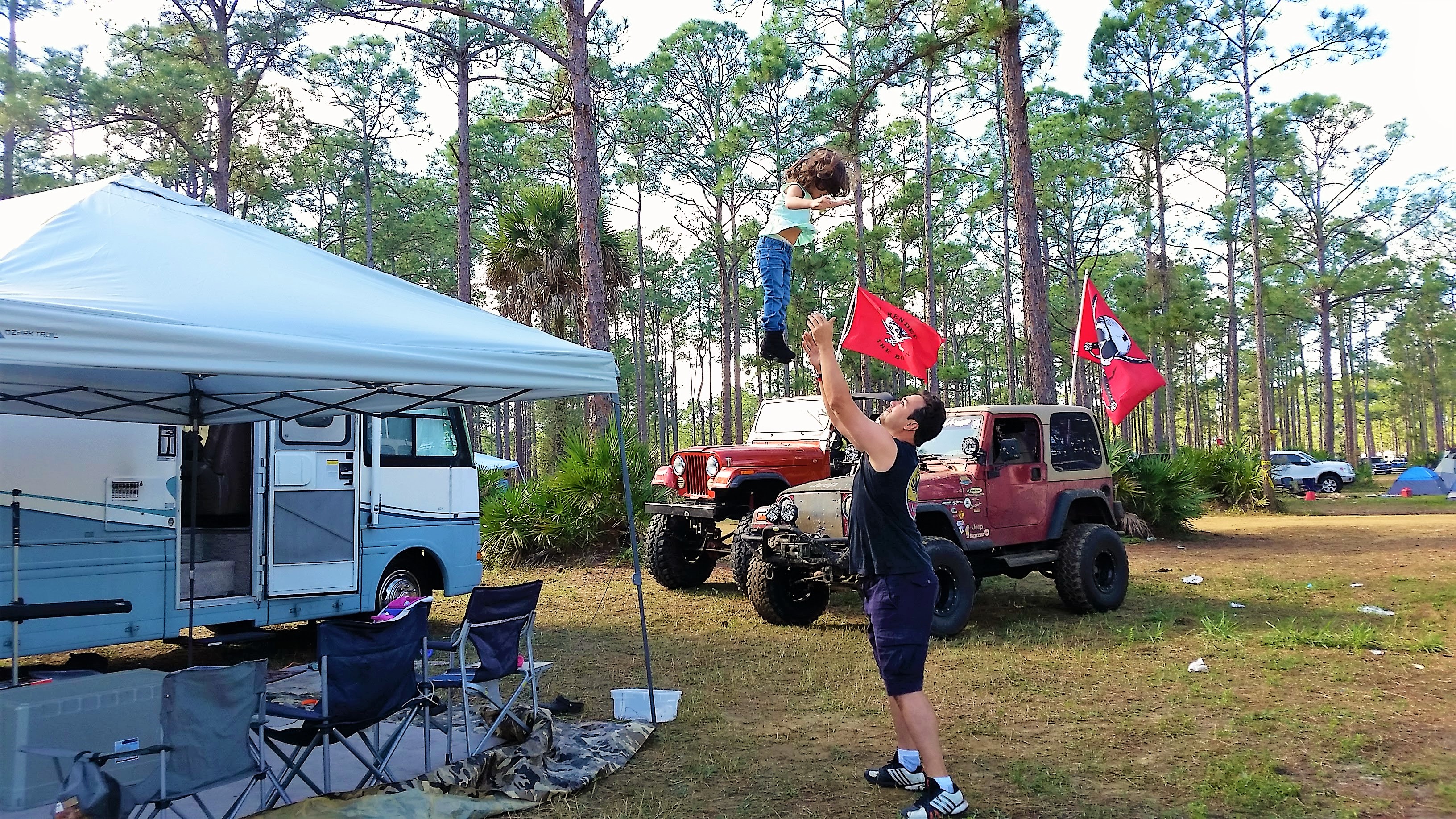 Man tossing child up in the air to play.