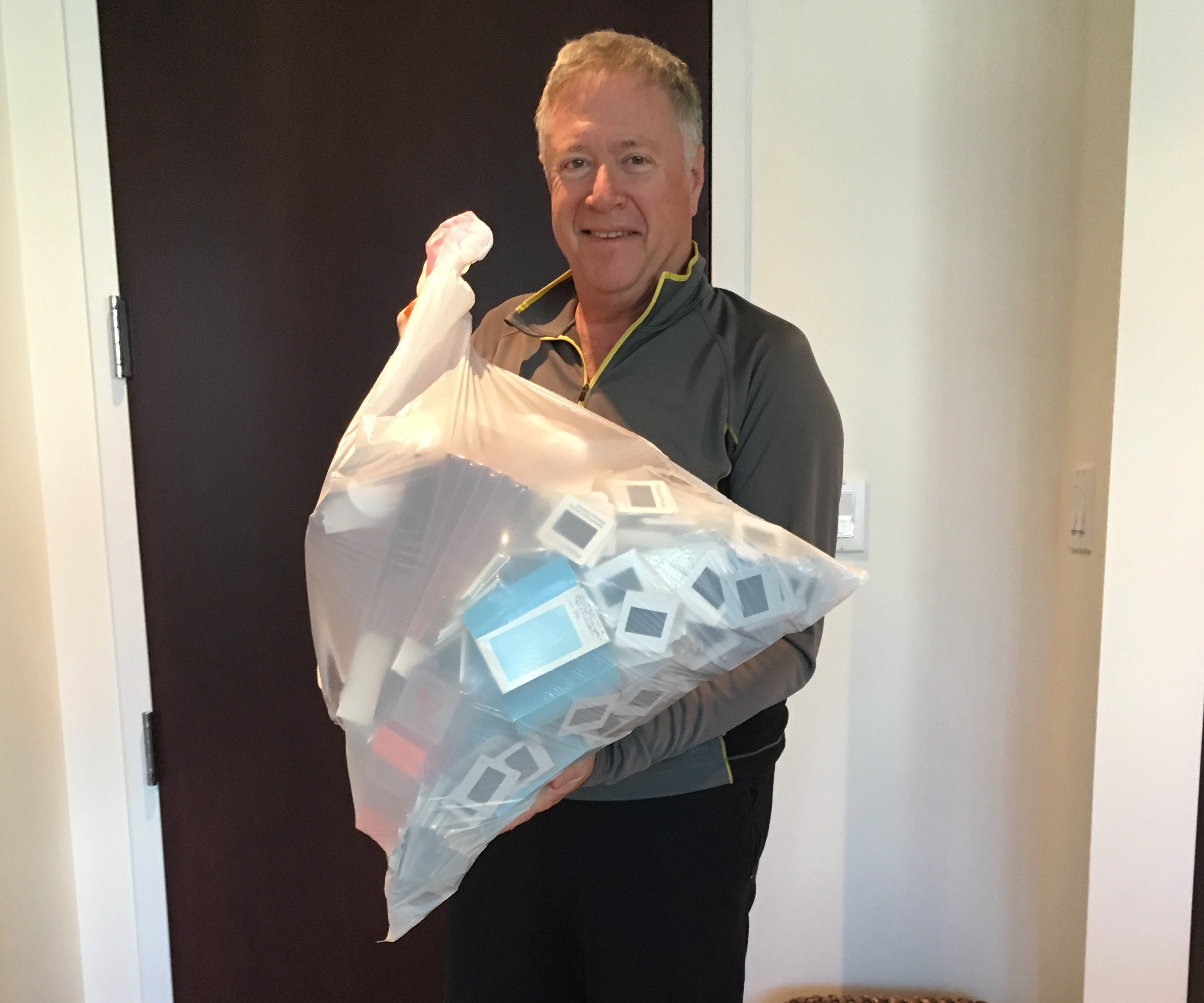 Man with a trash bag of old photos.