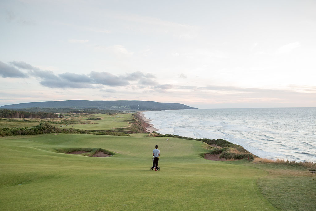 Jordan walking along the fairway with water to the right.
