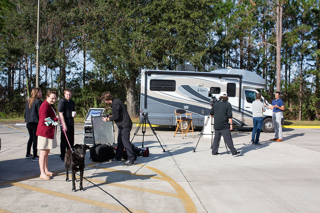 Jordan standing in front of Winnebago View being interviewed by camera crew.