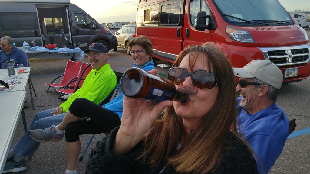 People gathered together socializing among Winnebago Travatos.
