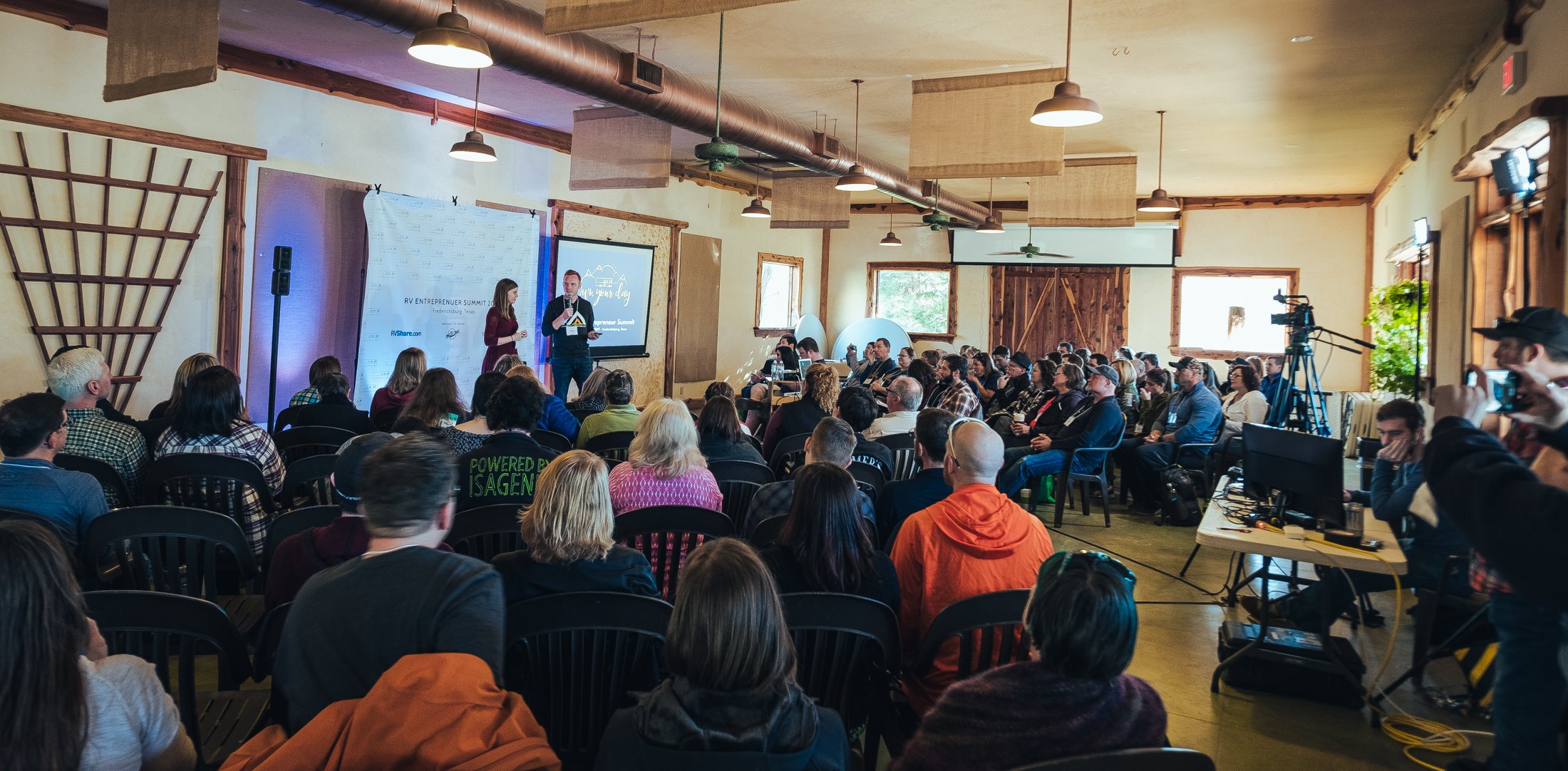 Heath and Alyssa on stage talking to crowd of attendees.