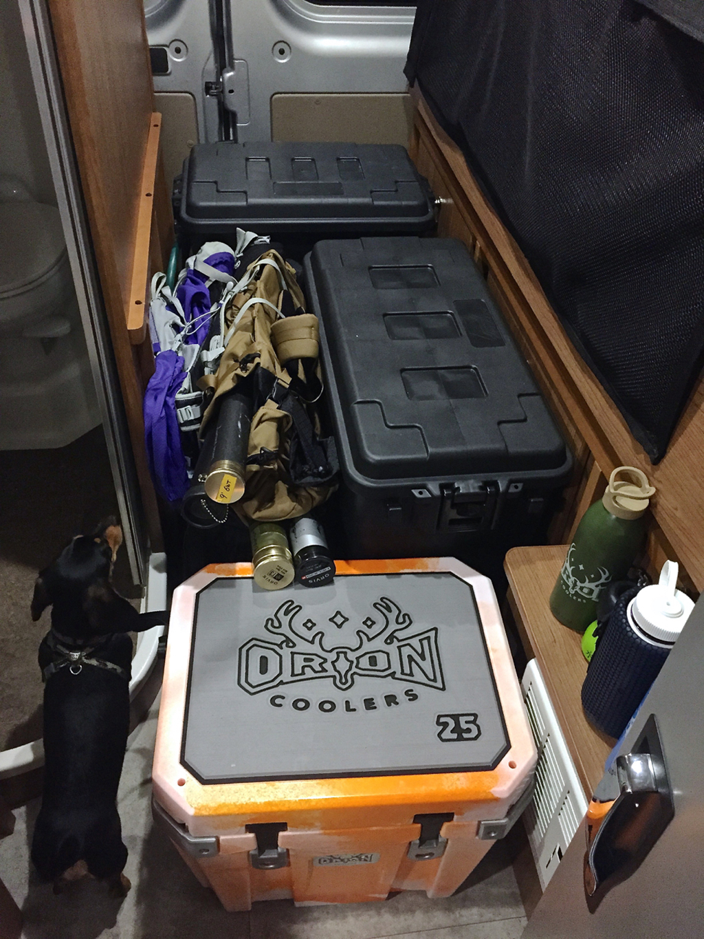 Totes and a Orion Cooler on the floor of the backside of RV.