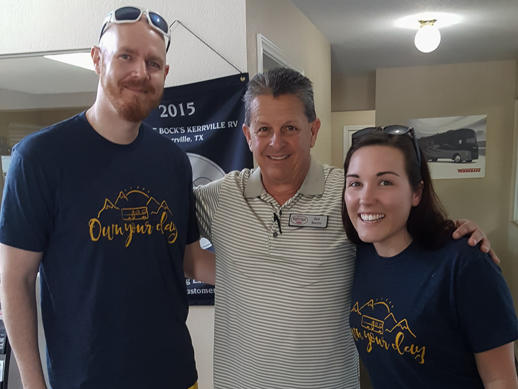Couple standing with their RV Salesman.