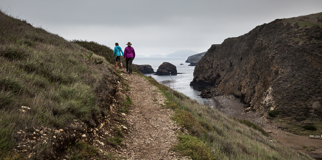 Kathy and Abby hiking along a trail along the water.