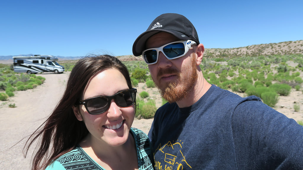 Couple taking a selfie with their Winnebago View parked in the background.
