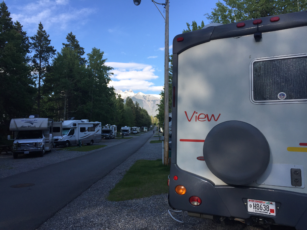 Winnebago View parked among other RVs in campground with mountains in the distance.