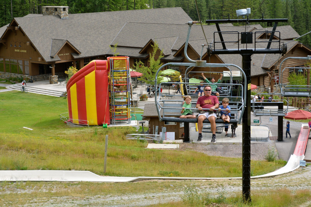 People on a gondola ride up to the top of the mountain with the Whitefish Resort below.