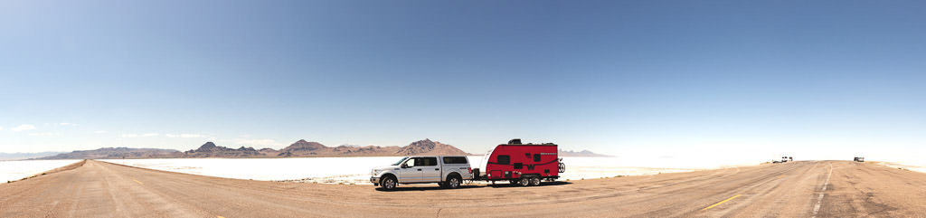 Truck hauling Winnebago Minnie parked with white fields of Salt Flats spanning the landscape behind.