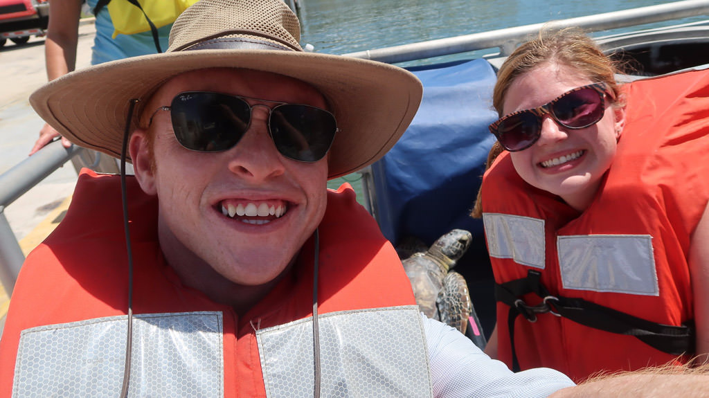 Heath and Alyssa in life jackets on a boat.
