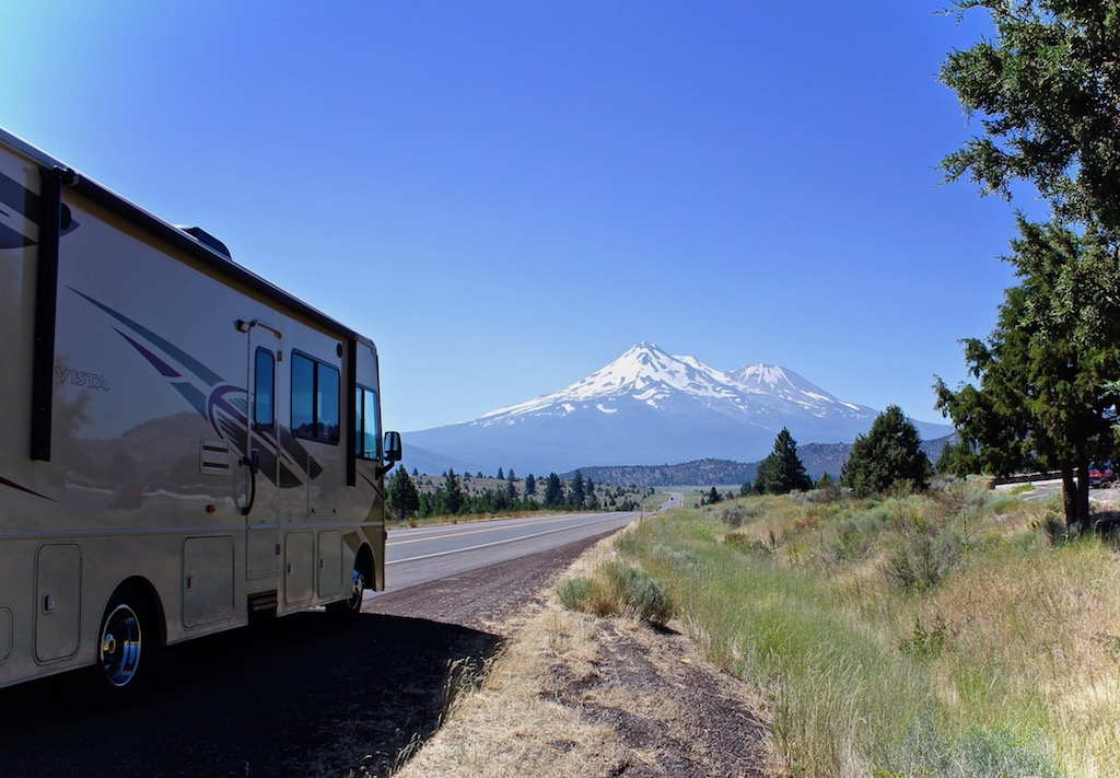 Winnebago Vista parked on the side of the road with mountain ahead.