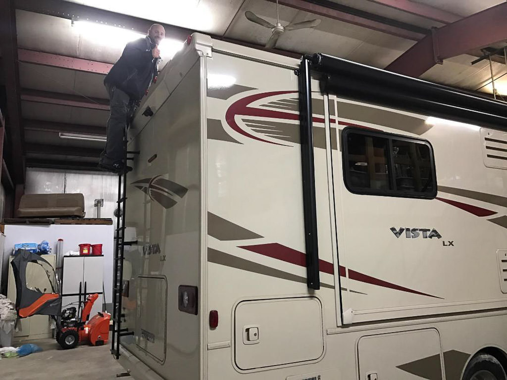 Kenny at the top of the back ladder on Winnebago Vista LX.